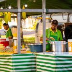 Vendedores preparam pratos à base de milho em uma barraca de comida de rua.